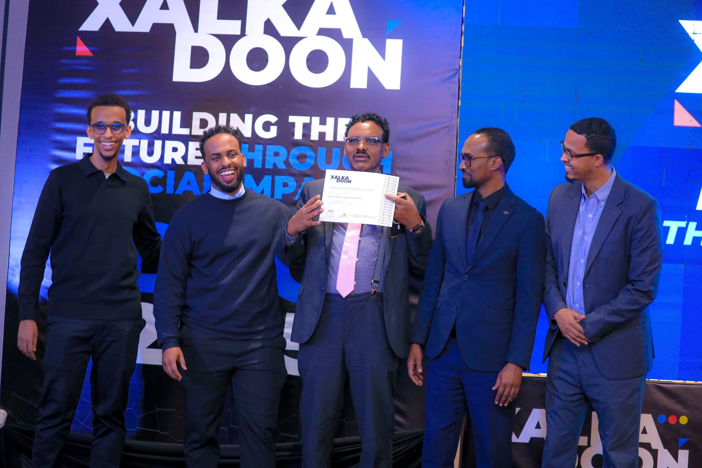Mohamed receiving a certificate of appreciation at Xalkadoon 2025