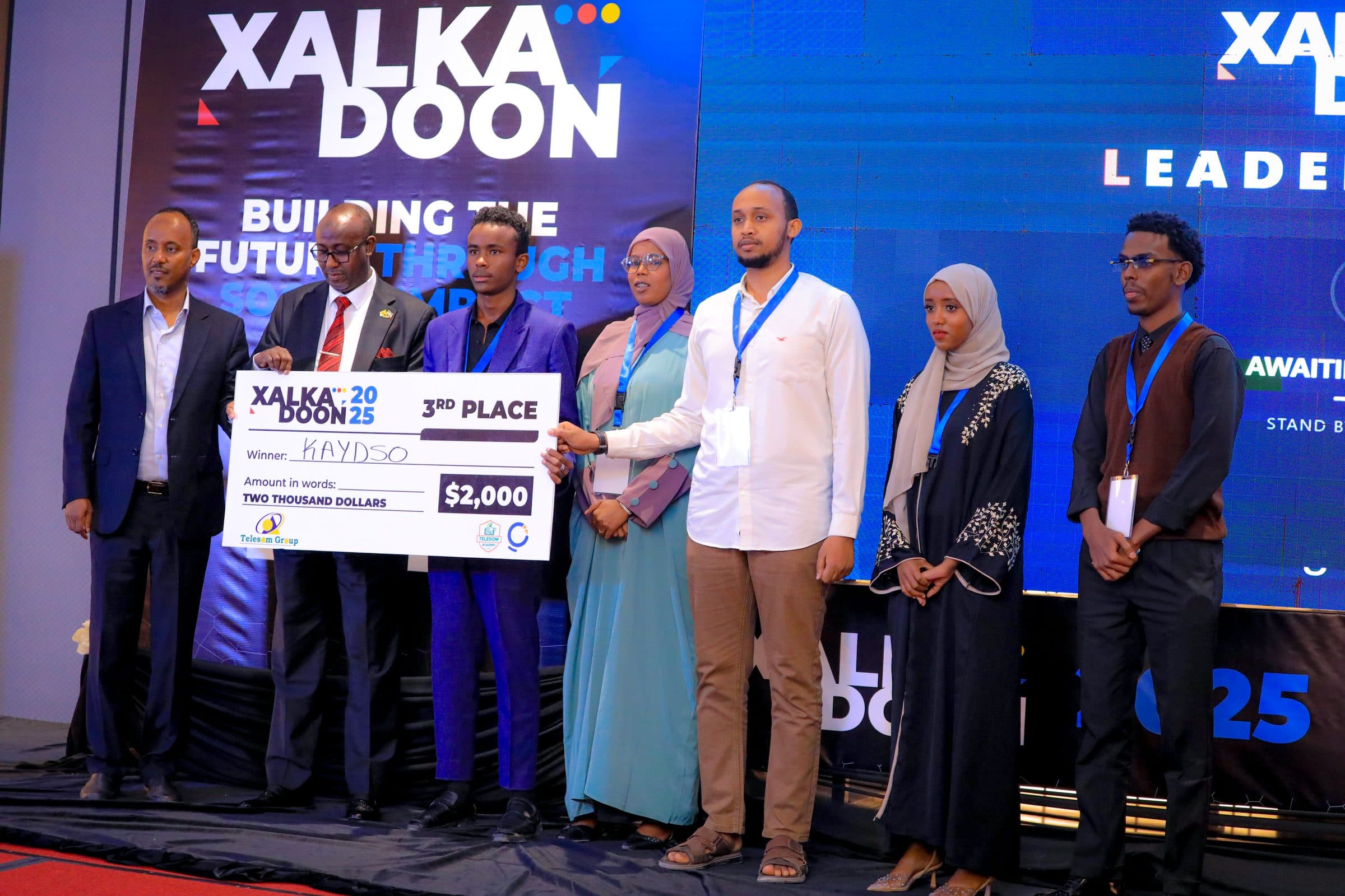 Kaydso receiving the $2,000 third place prize at Xalkadoon 2025